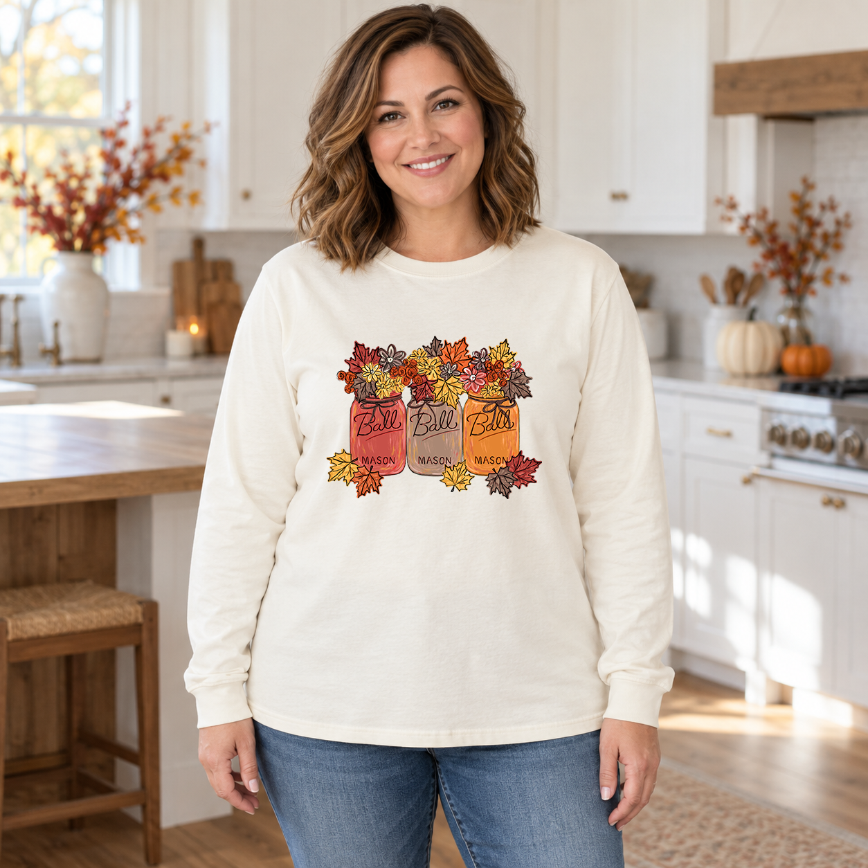 Woman wearing an ivory long-sleeve tee with Fall Leave Mason Jars autumn floral transfer