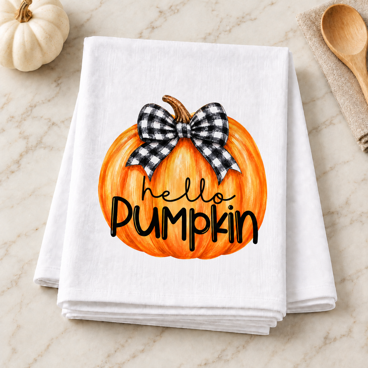 Hello Pumpkin transfer displayed on a folded white towel in a fall kitchen setting