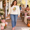 Woman wearing an ivory sweatshirt with colorful Preppy Turkey in pink boots