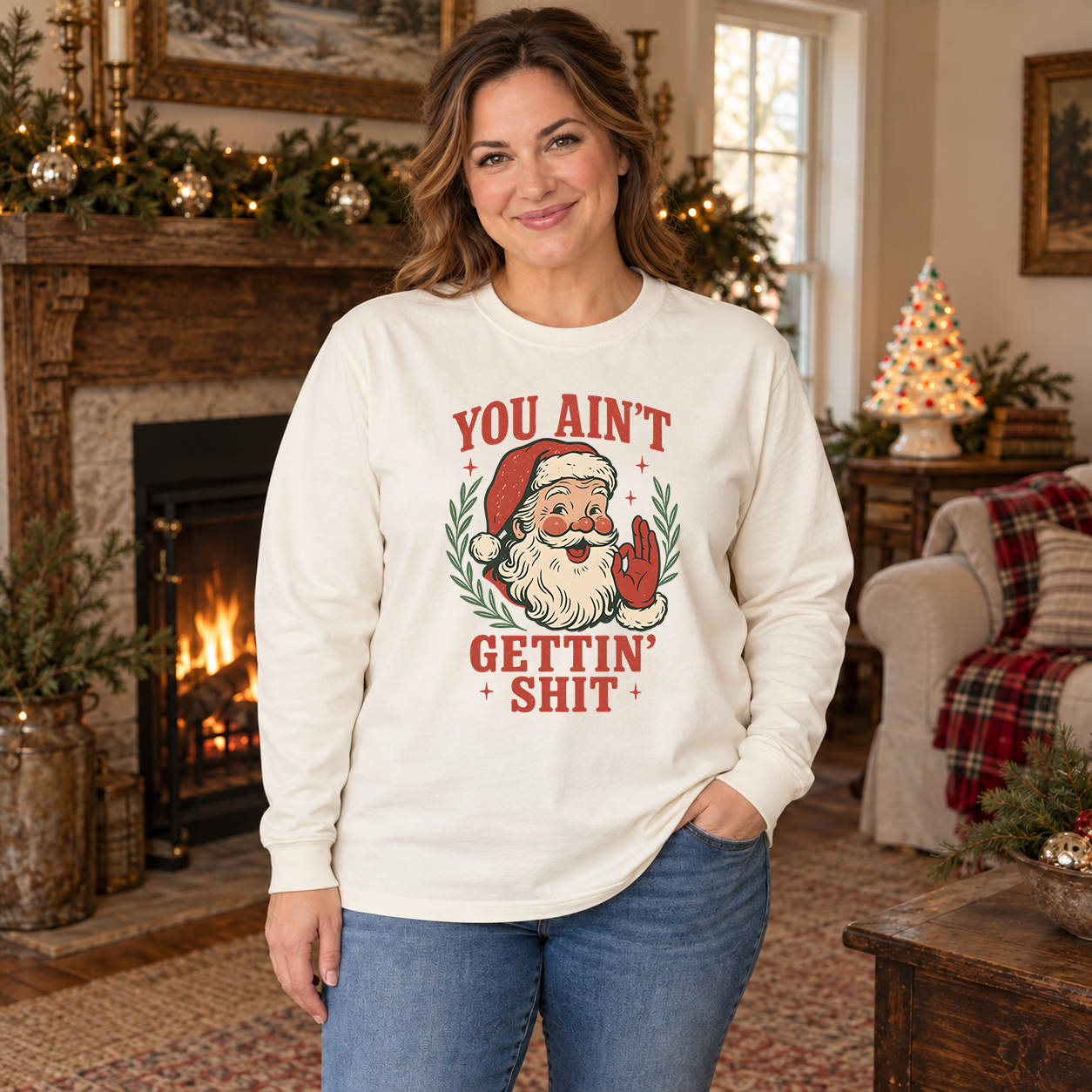Woman wearing an ivory long-sleeve tee with retro You Ain't Gettin Shit Santa design